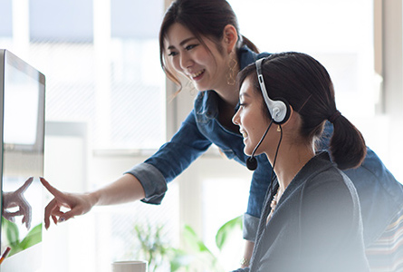 Two business women looking at a computer monitor