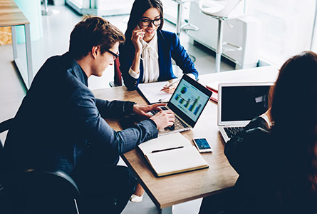 man and two women working at desk