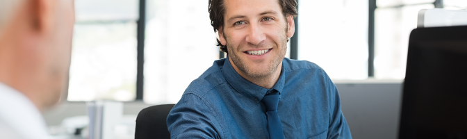 Close up of young businessman giving writing pad to senior businessman.