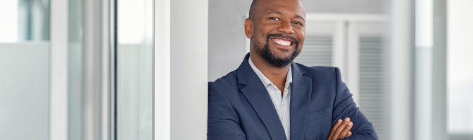 Mature cheerful african american executive businessman at workspace.