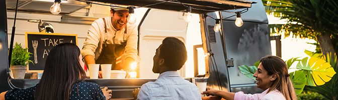 Three people standing at a food truck.