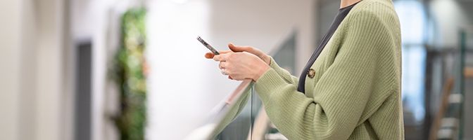 A person viewing a mobile phone in their hands.