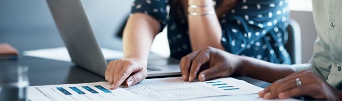 Closeup of two business partners going over financial statements.