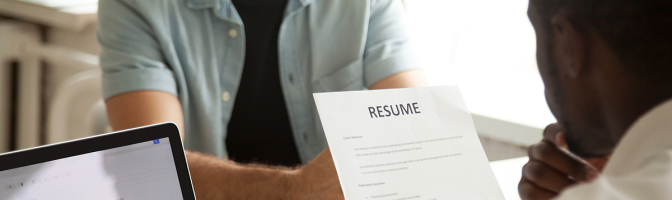 hr hiring manager holding applicants resume at job interview