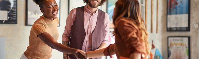 Business woman at a job interview shaking hands with interviewers