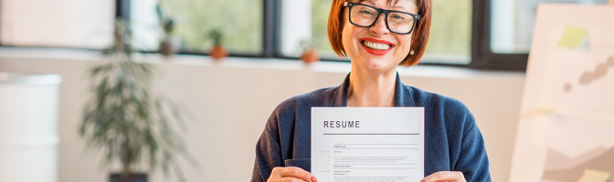 Elegant older woman holding resume document sitting in office