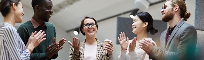 An employee is praised in front of co workers during a meeting.