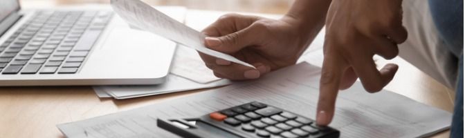 Businesswoman using a calculator while holding a receipt