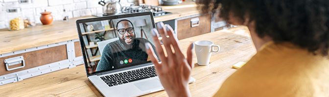 Job applicant waves at HR recruiter during a virtual hiring interview.