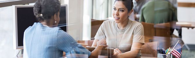 two women having a discussion at a table