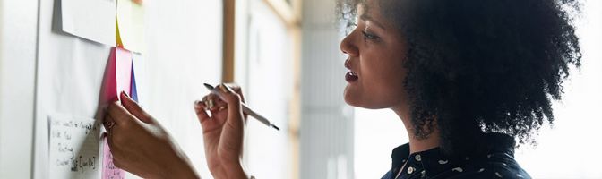 woman writing notes on a board