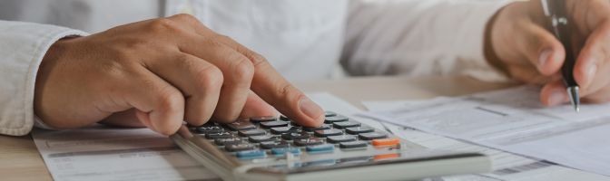 business person using calculator and pen