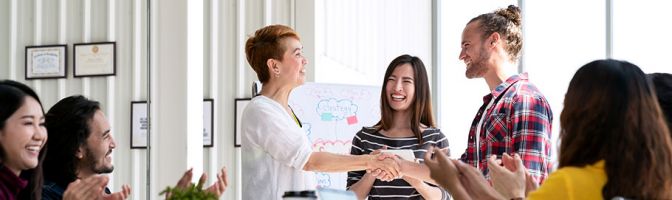 man and woman shaking hands at a meeting