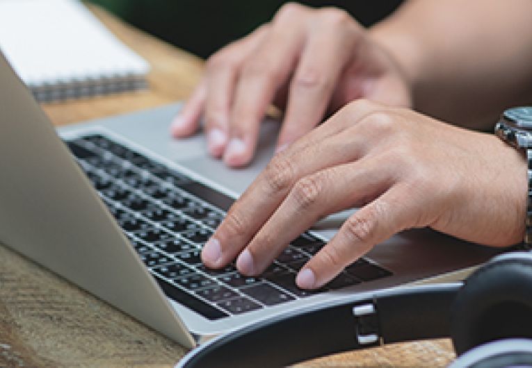  A person typing on a laptop.