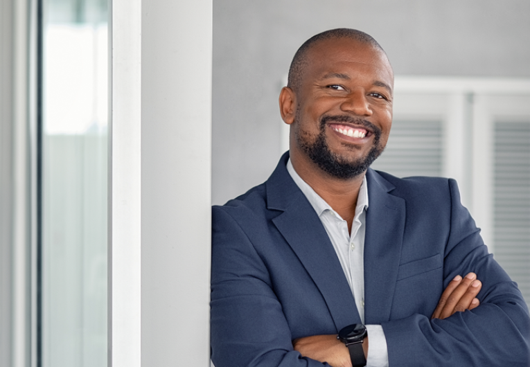 Mature cheerful african american executive businessman at workspace.
