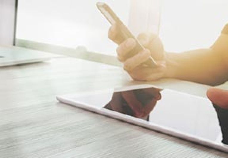 Man using mobile phone near laptop and tablet