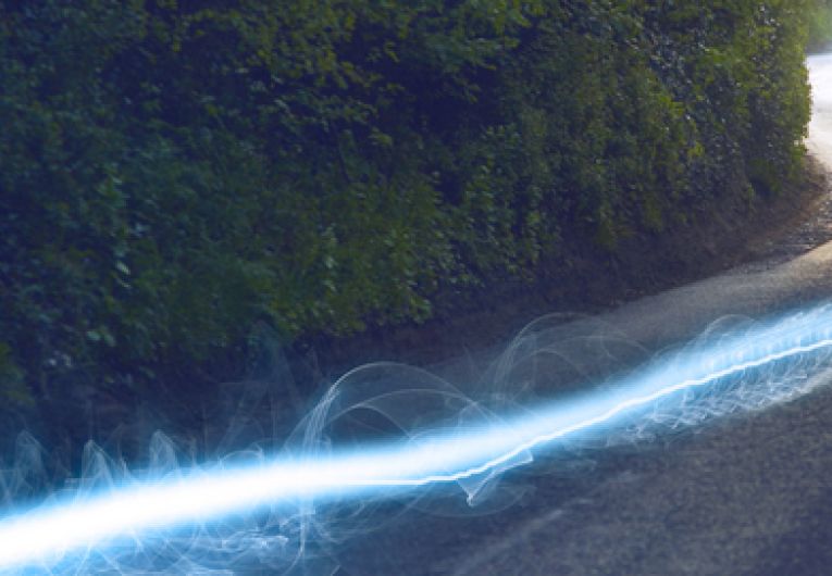 streaks of light blazing down a rural paved street