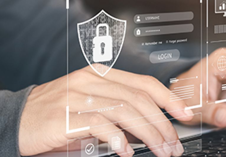 Cybersecurity icons overlay image of person typing on a laptop.