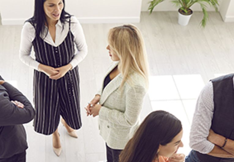 A group of business owners stand around an event networking.