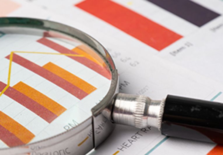 Magnifying glass over business report.