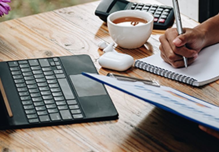 A small business owner goes over financial records at an office desk.