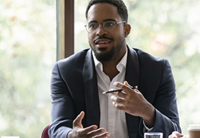 A small business owner talks to their team during a meeting.