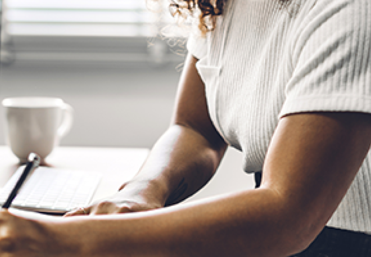 A entrepreneur takes notes during the year-end audit of their business website.