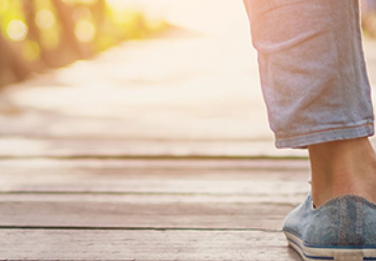 Closeup of the shoes of a person taking a relaxing stroll.