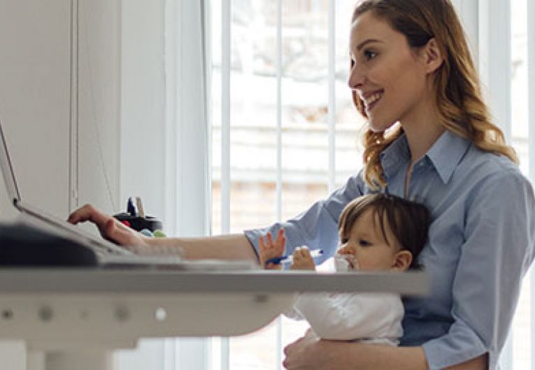 woman working at desk with baby on lap