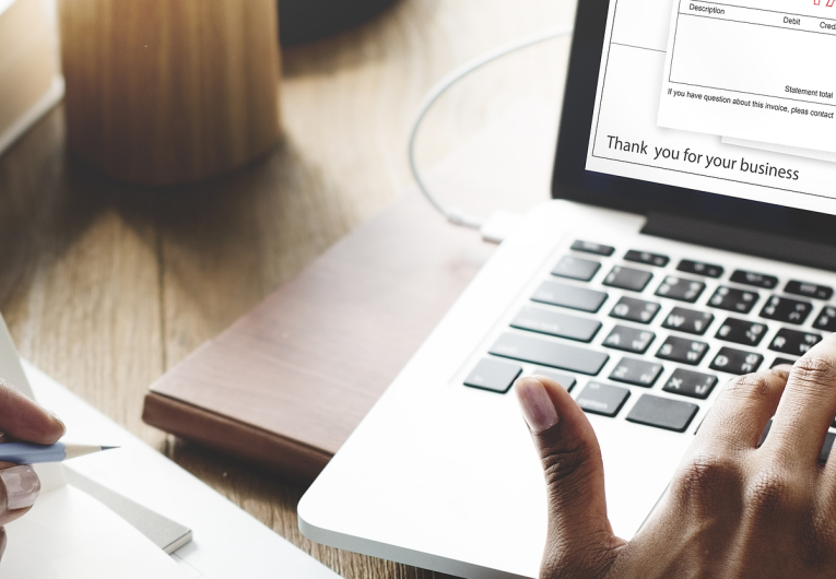 Woman working on computer looking at online invoice.