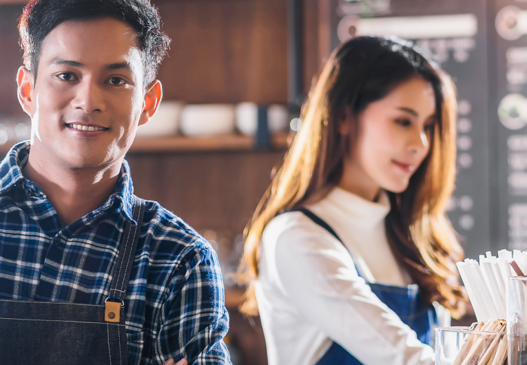 Male and female working at coffee shop. 