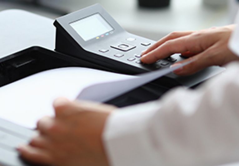 Closeup of business person using an office printer.