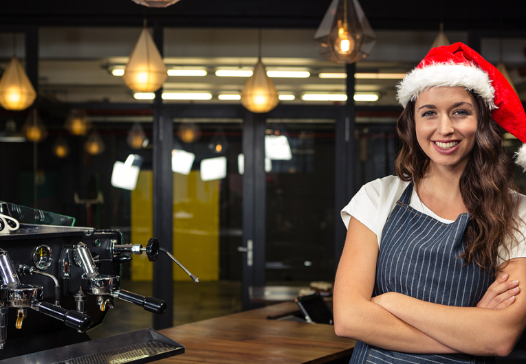 Barista wearing Santa hat at coffee shop