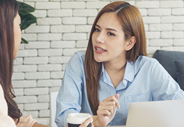 Two people talking in an office setting.