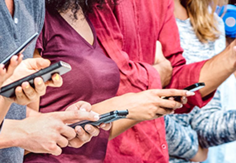 A group of people looking at their smartphones.