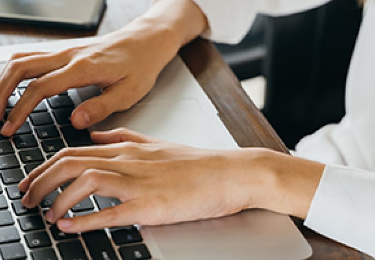 A person typing on a laptop.