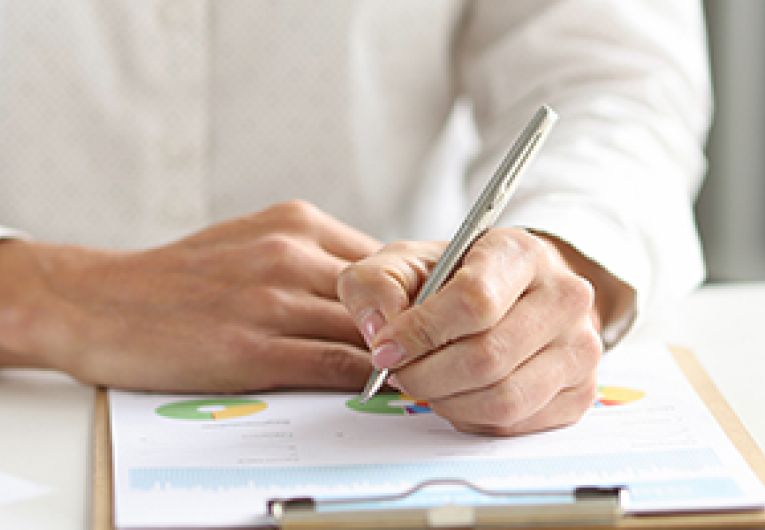 A small business owner looks over financial information while sitting at their desk.