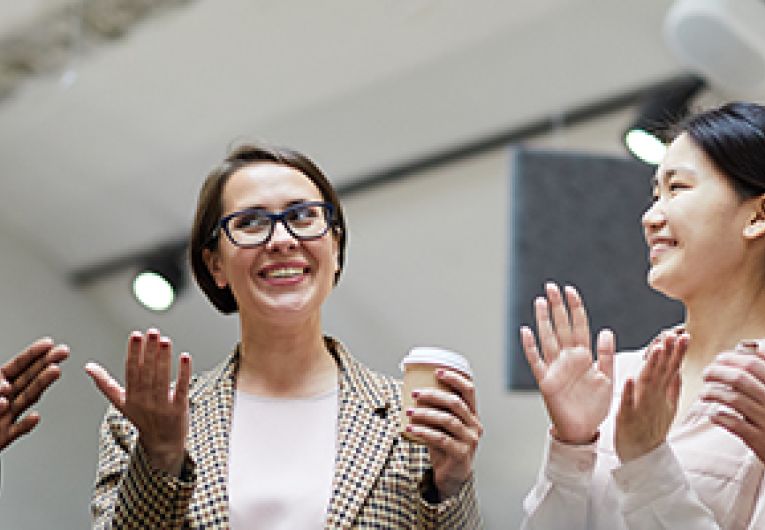 An employee is praised in front of co workers during a meeting.