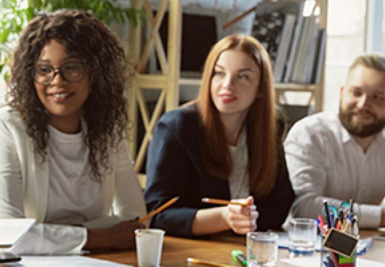 A group of staff members having a discussion during a meeting.