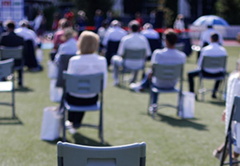 Outdoor event with people gathered while social distancing.