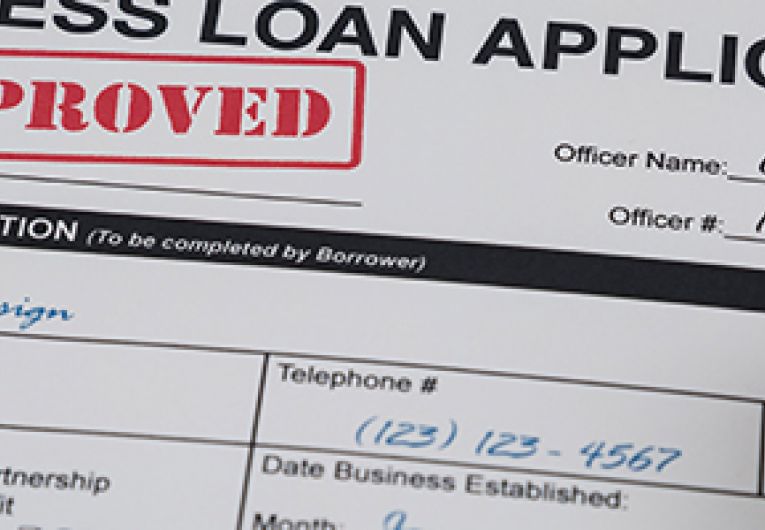 Business loan application shown with a red "Approved" stamp.