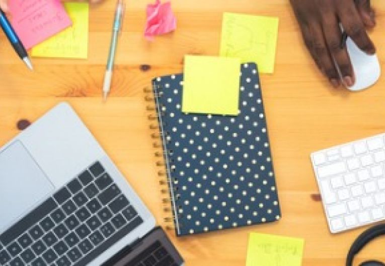Employees in a small office brainstorm ideas in front of a laptop