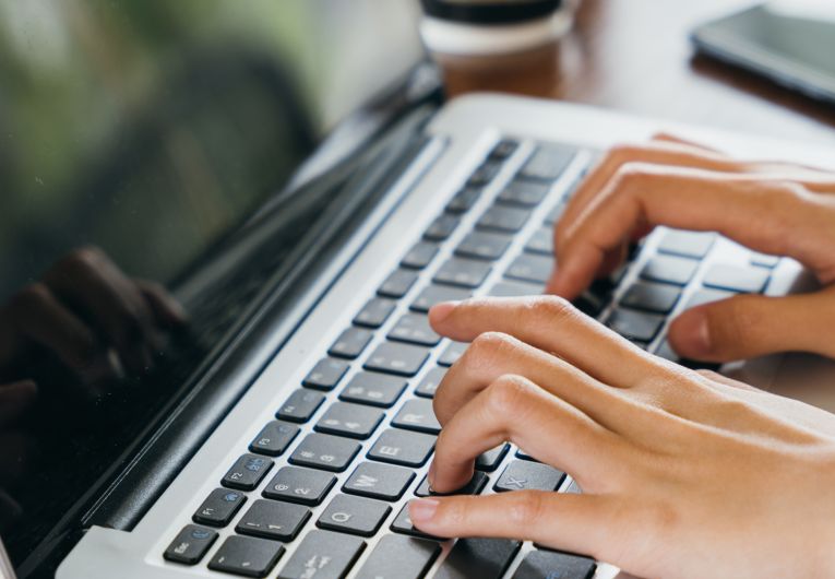 hands typing on laptop