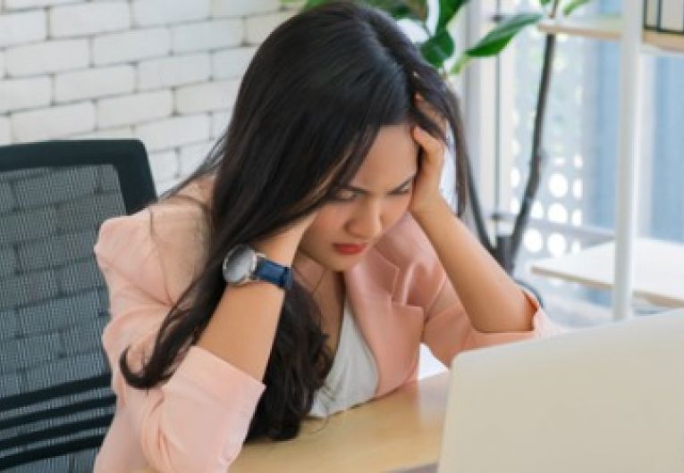 Stressed small business owner sitting in front of a laptop 