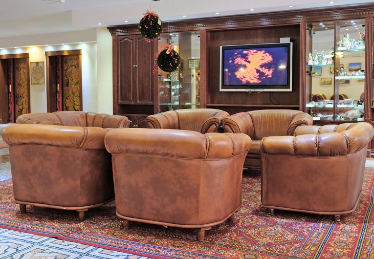 Image of office chairs in a lounge at a hotel with a TV playing