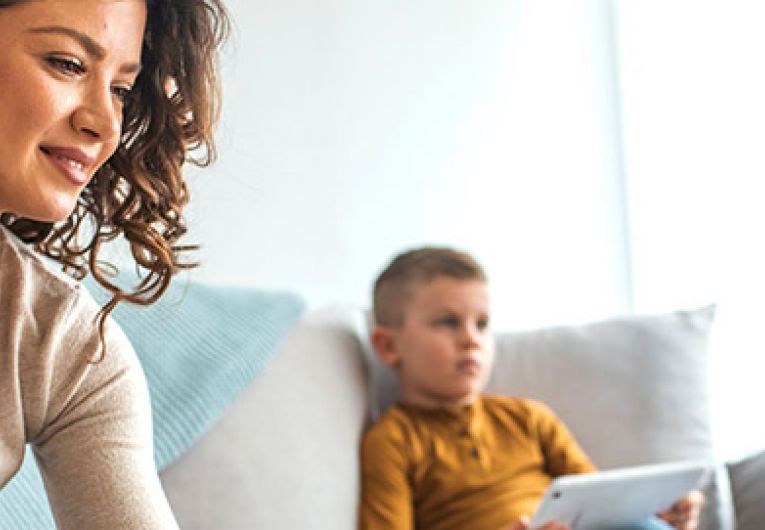 family using devices in their living room