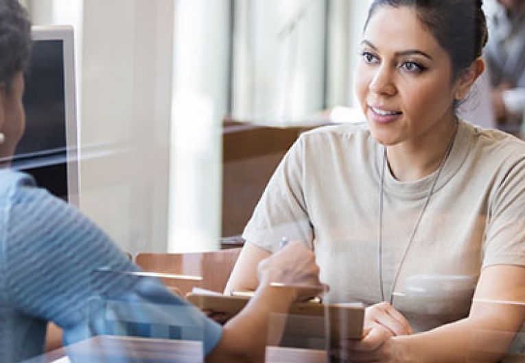 two women having a discussion at a table