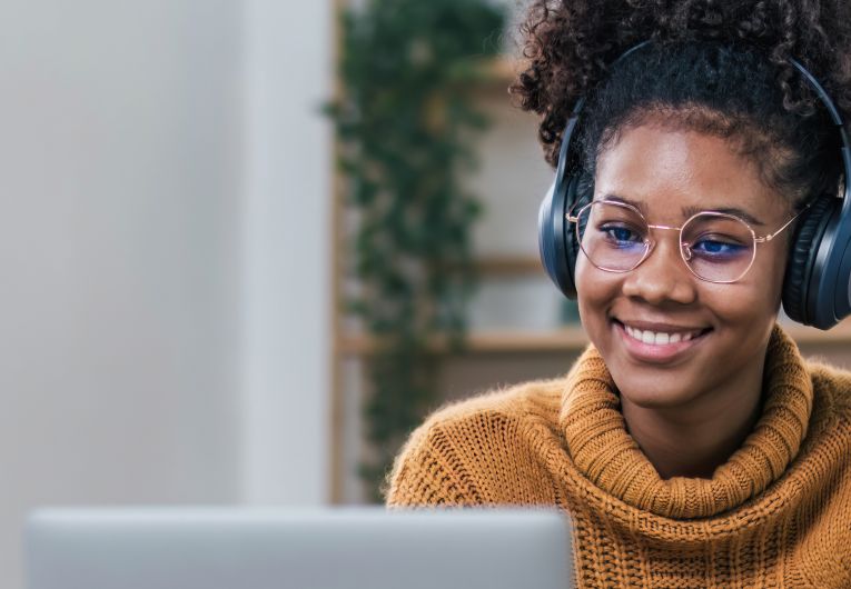 woman smiling at camera on computer working from home