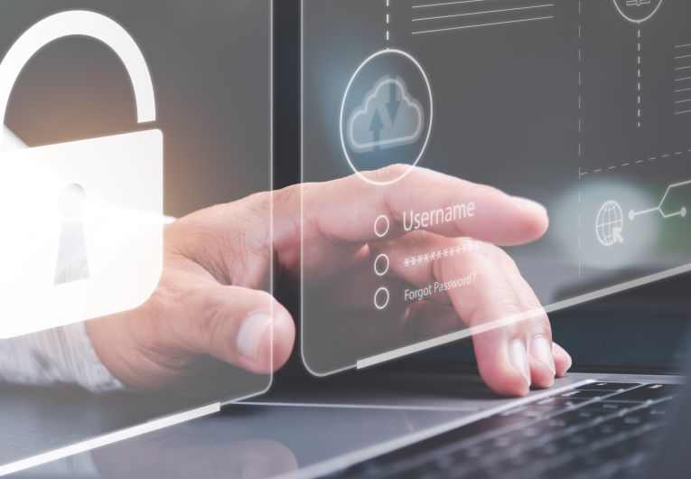 man's hand clicking on laptop surrounded by cyber security graphics