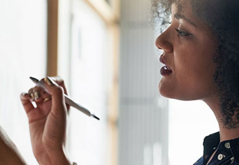 woman writing notes on a board